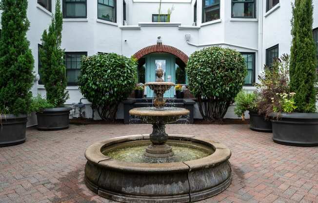 a fountain in a courtyard in front of a building