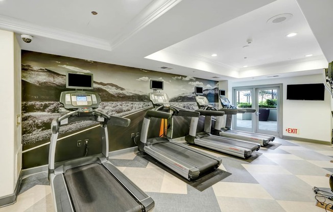 a gym with treadmills and televisions  at Apex Mission Valley, San Diego, California