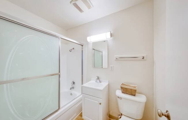 A white toilet sits next to a sink in a small bathroom.
