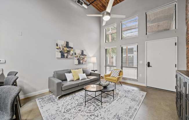 a living room with a gray couch and a yellow chair