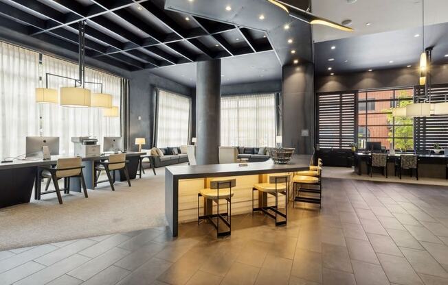 the lobby of a hotel with tables and chairs and a bar