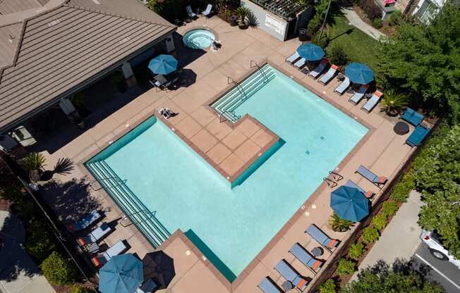 a large swimming pool with umbrellas and chairs around it