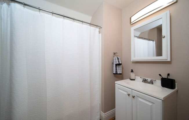 Model unit bathroom with white fixtures at the Atrium Apartments in San Diego, California.