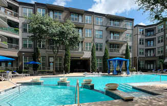 A large swimming pool in front of apartment buildings.