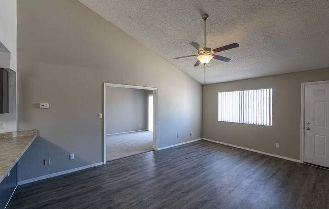 an empty living room with a ceiling fan