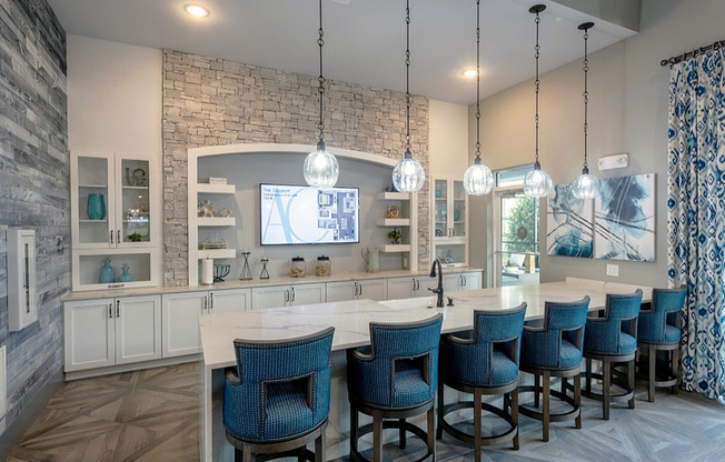 View of The Addison at Clermont Clubroom Showing Blue Bar Stools, Pendant Lighting, Large Flat Screen TV and Stone Walls