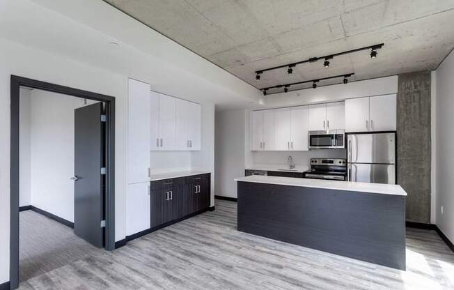A modern kitchen with a large island and stainless steel appliances.