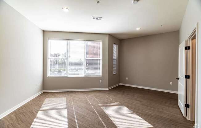 A room with a large window and a wooden floor.