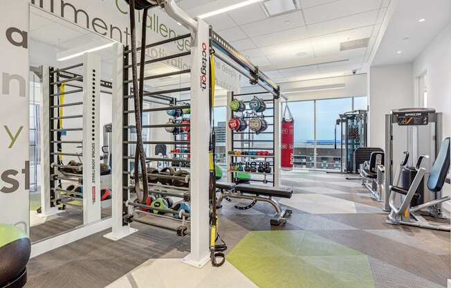 A gym with a variety of equipment including a pull up bar, weights and a bench.