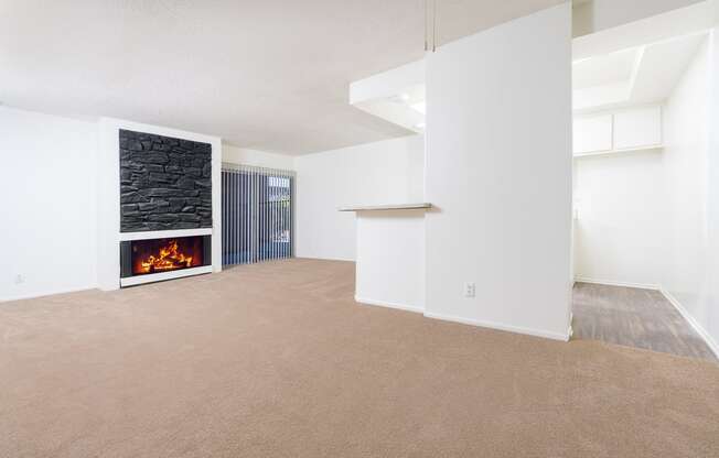 an empty living room with a fireplace and white walls