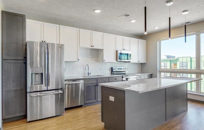 Large windows filter abundant natural light into the spacious kitchen in the Melody floor plan at Haven at Uptown in Lincoln, NE
