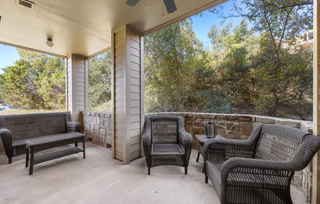 a covered patio with wicker furniture and a large window at The Verandah, Austin, TX