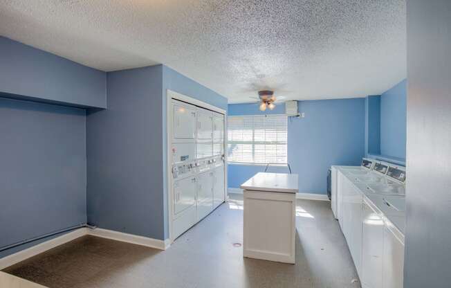 a blue and white kitchen with blue walls and white appliances