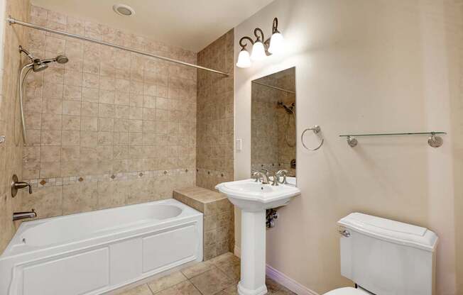 A bathroom with a tub, sink, and toilet.