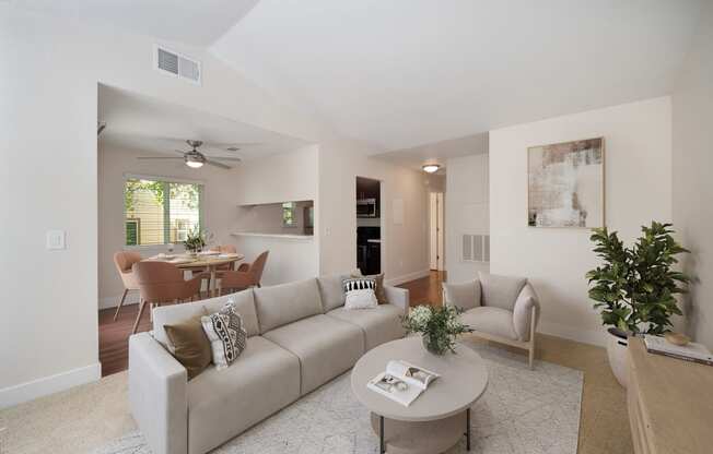 a living room with a couch and a coffee table with views of the dining room