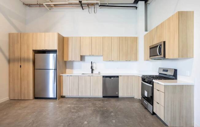 an empty kitchen with wooden cabinets and stainless steel appliances