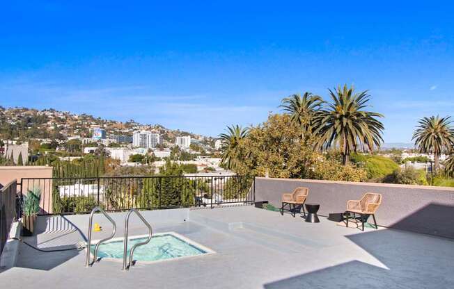 the pool on the roof of a house with a city in the background