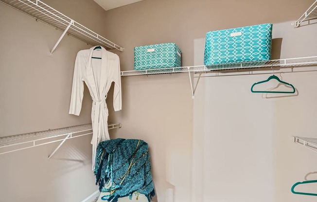 A white robe hanging on a rack in a room.