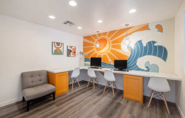 a room with a desk and chairs and a mural on the wall