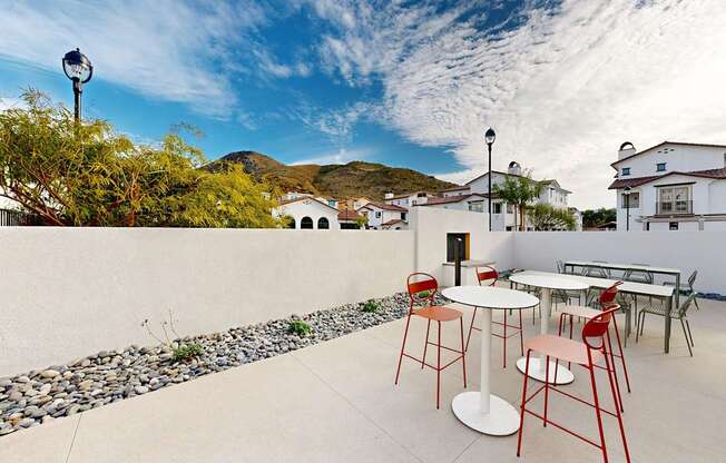 A patio with a table and chairs is set up on a sunny day at The Villas at Anacapa Canyon, Camarillo, 93012