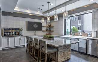 a kitchen with a large island with chairs and a counter top