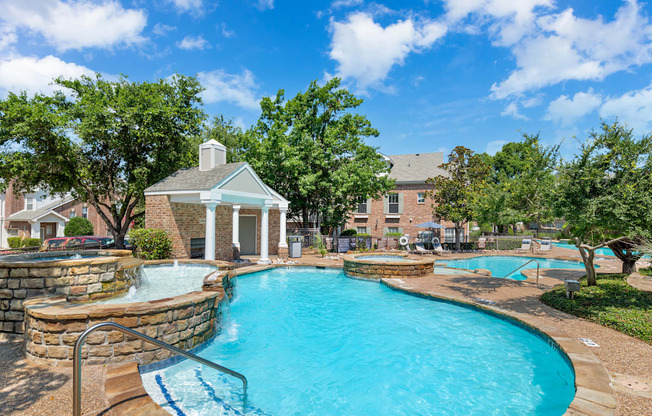 A swimming pool surrounded by a stone wall and a gazebo.