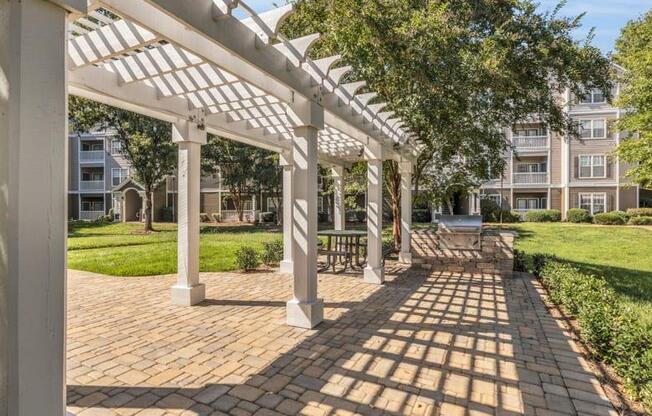 a pergola on a brick sidewalk in front of an apartment building at Marina Point, Chattanooga, TN