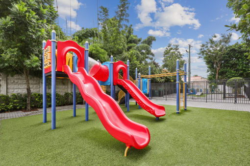 Red playground with slides at Bay Village 1 in Palmetto Bay, FL