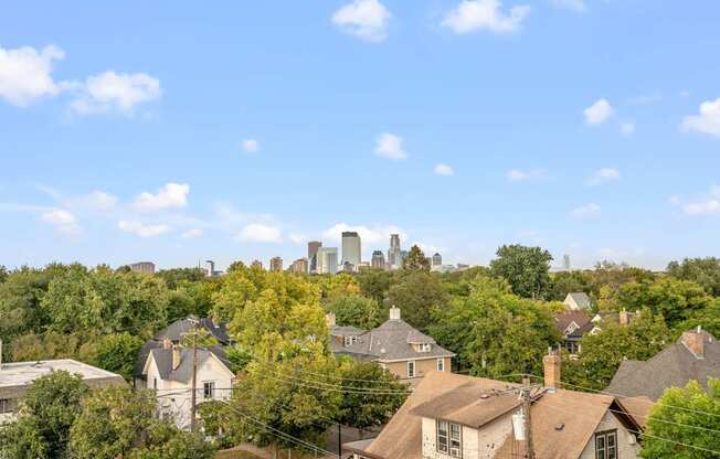 A city skyline is visible in the distance behind a row of houses.