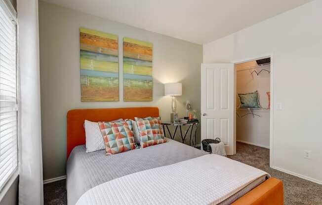 a bedroom with a bed and two paintings on the wall