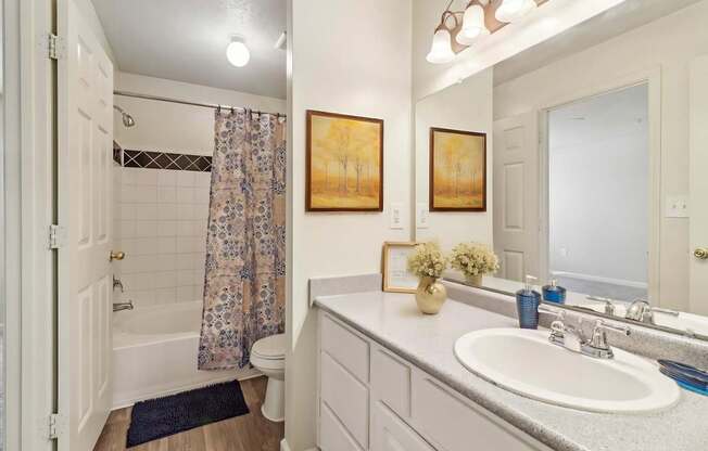 A bathroom with a white sink and a white toilet.
