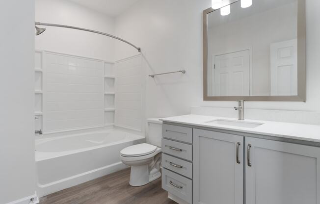 a white bathroom with a tub and a sink and a toilet