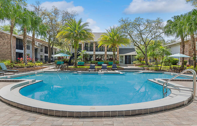 Community Swimming Pool with Pool Furniture at Grand Pavilion Apartments in Tampa, FL.