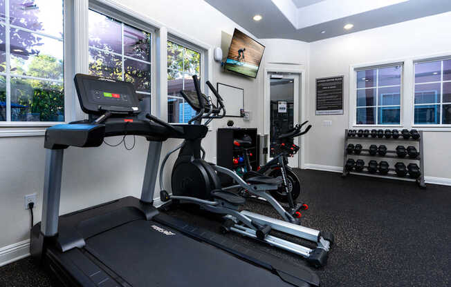 A black treadmill with a digital display in a well lit room.