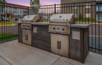 Community grills in a fenced in community space.