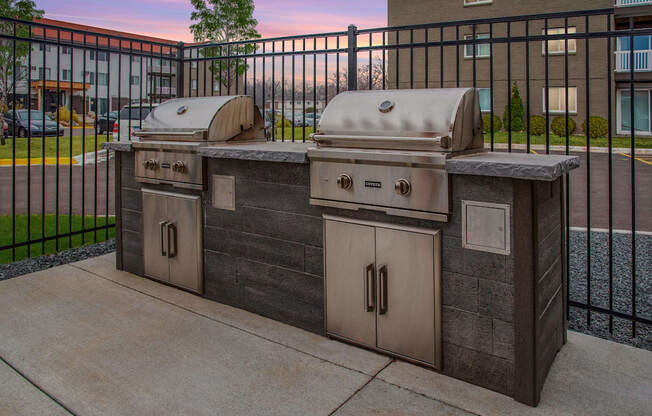 Community grills in a fenced in community space.