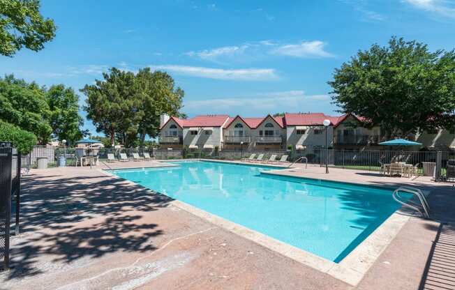 Swimming Pool area with lounge chairs and umbrellas.