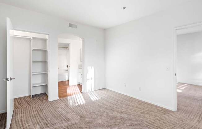 A large, empty room with a carpeted floor and white walls.