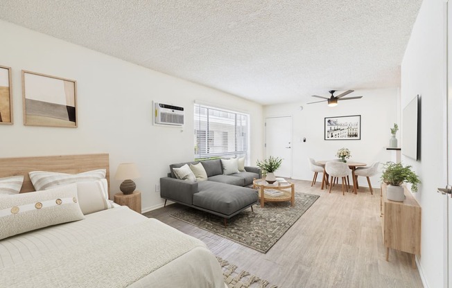 A bedroom with a large bed and a grey couch.