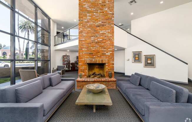 a living room with couches and a large brick fireplace