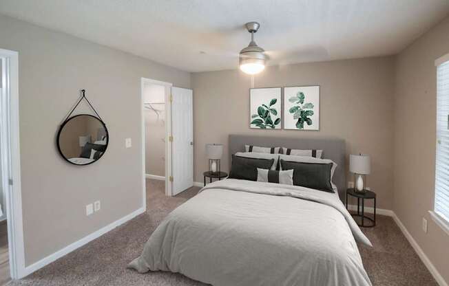 A bedroom with a large bed and a mirror on the wall.