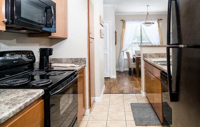 A kitchen with black appliances and wooden cabinets.