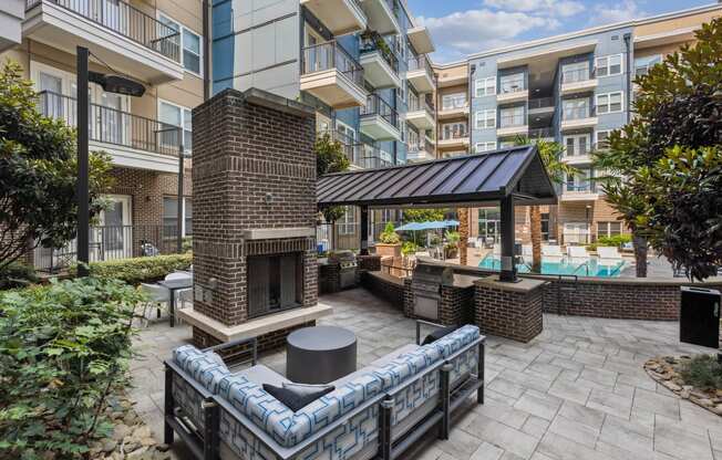 a patio with a fireplace and a pool in front of an apartment building