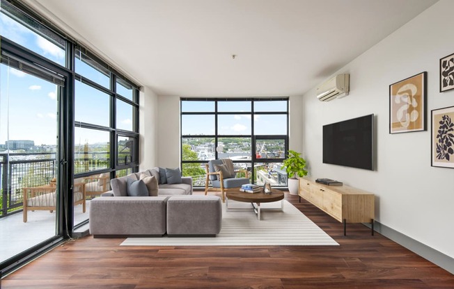 Living room with a couch and a coffee table and large windows at Equinox, Seattle, WA, 98102