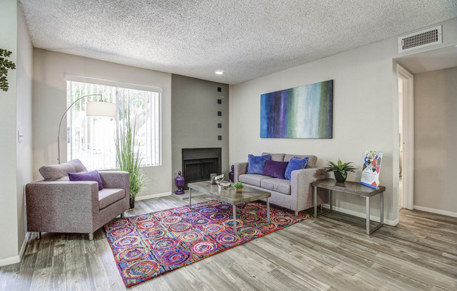 a living room with couches and chairs and a rug