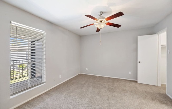 the living room of a house with a ceiling fan