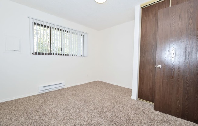 a bedroom with white walls and carpet