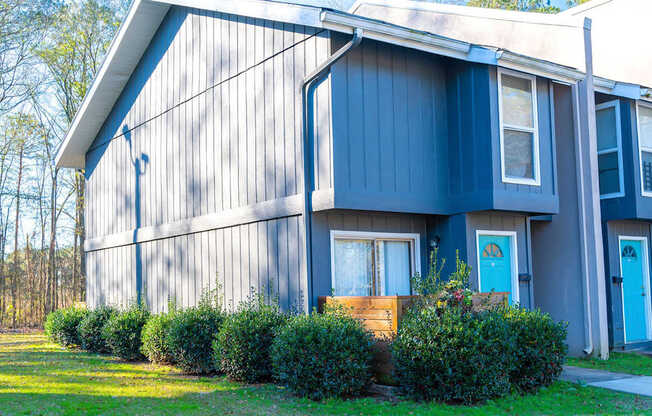 A blue house with a white door and windows.