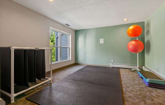 a room with a yoga mat and a balloon in the corner