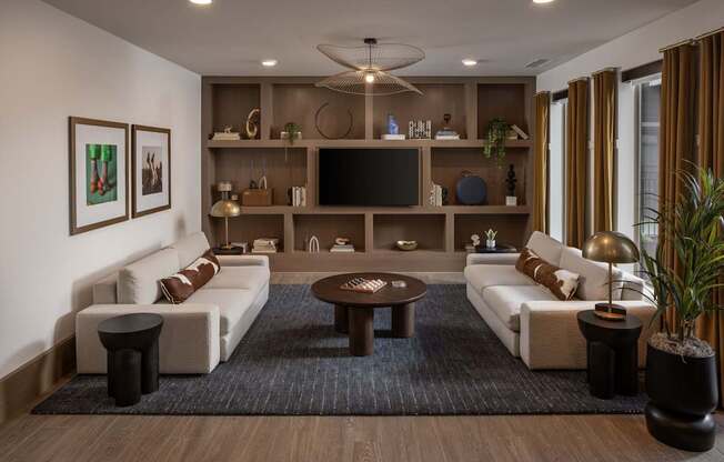 A modern living room with a white sofa, a coffee table, and a television on a wooden entertainment center.